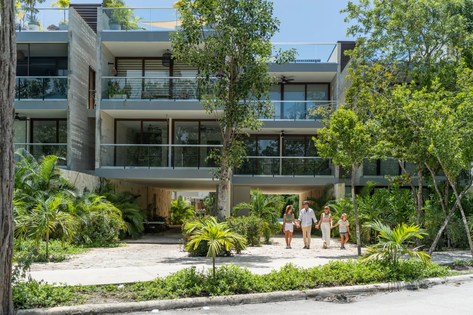 TAO Tulum entregado y habitado, con familias caminando entre la vegetación del conjunto